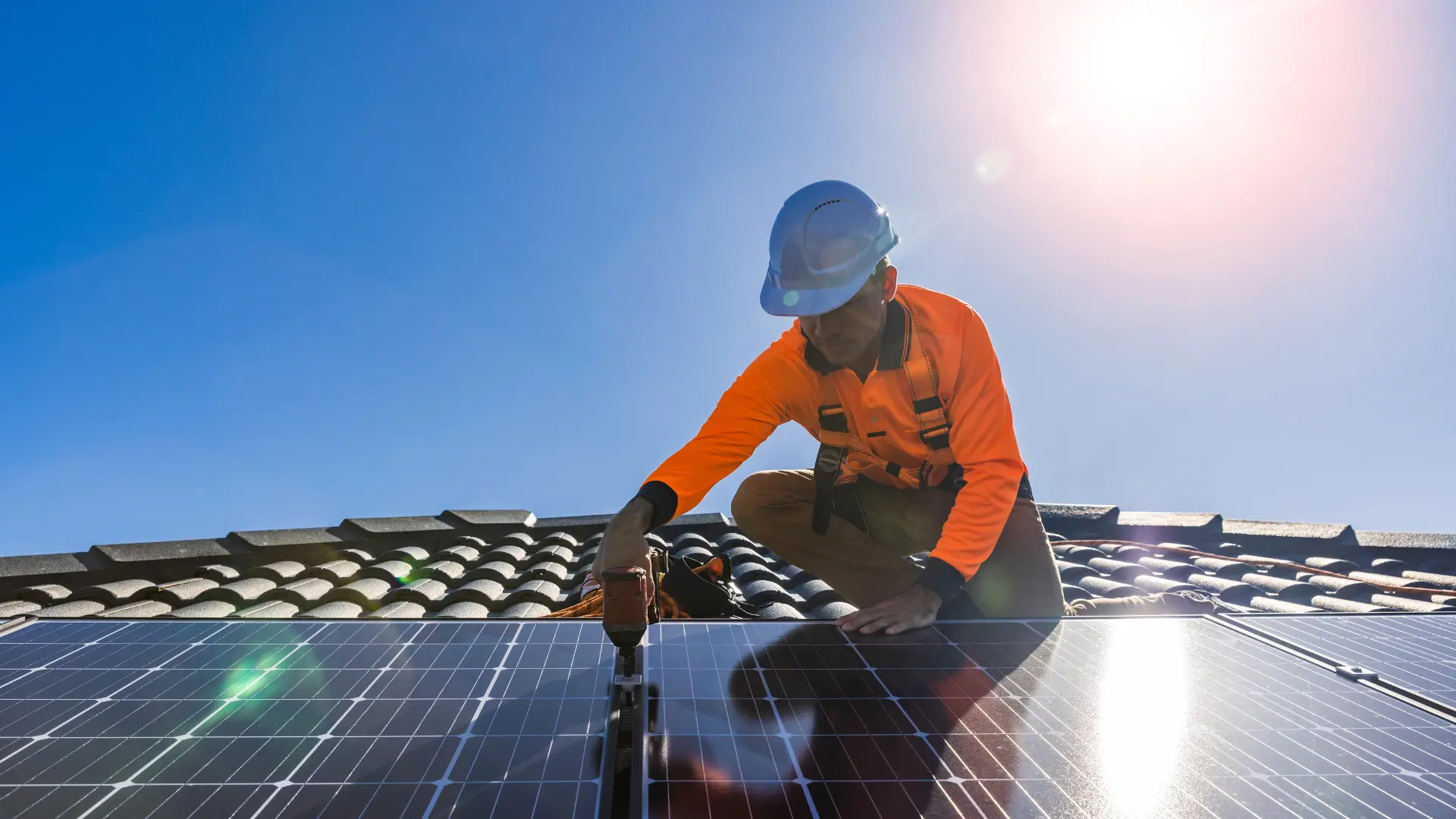 Solar installer securing panels to a roof