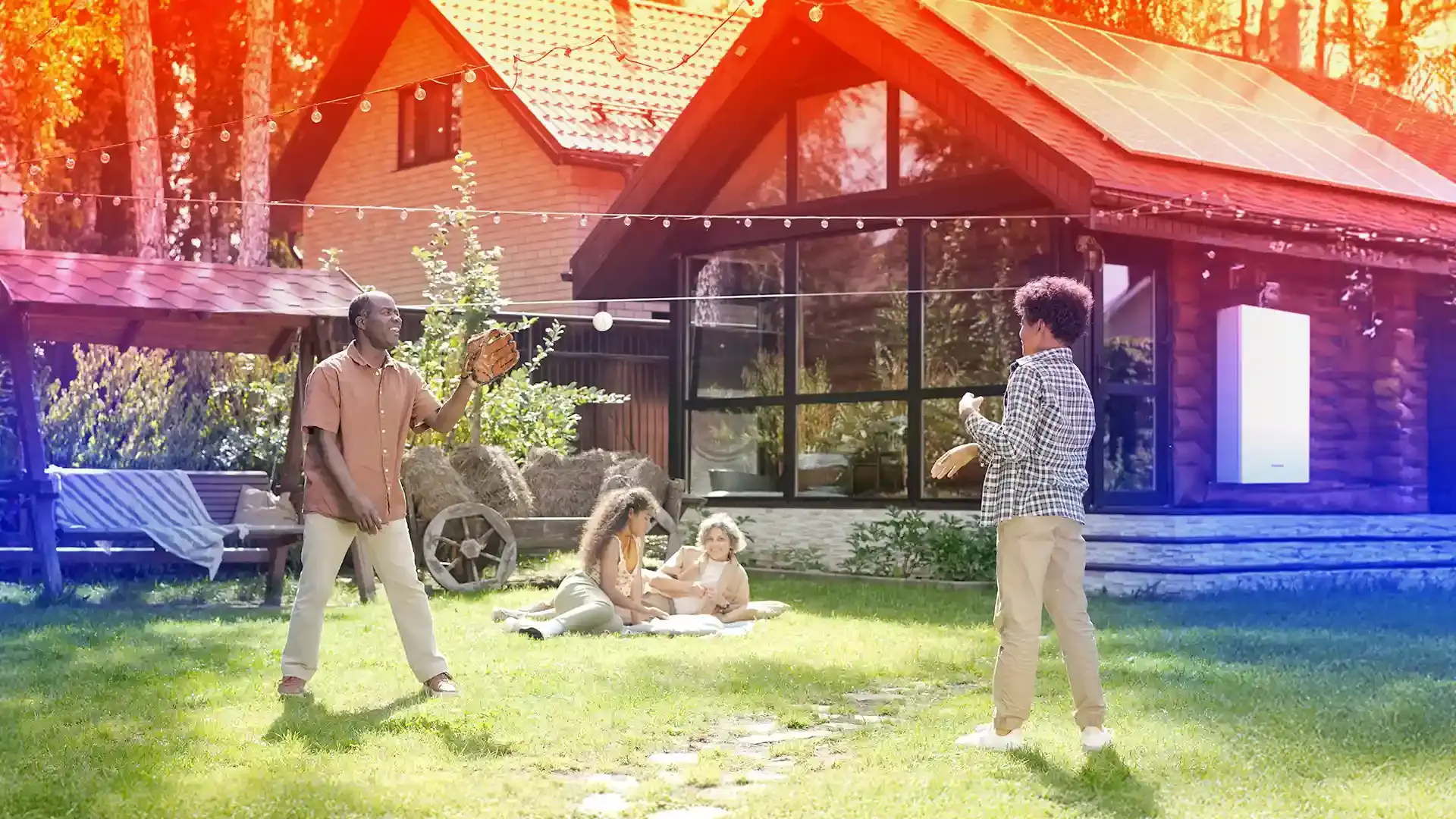 family enjoying a game of catch with solar panels and battery backup in the background
