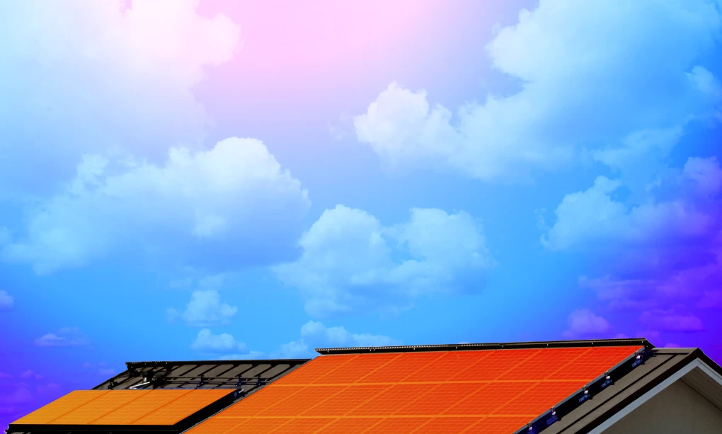 Solar panels on top of a house with blue skies