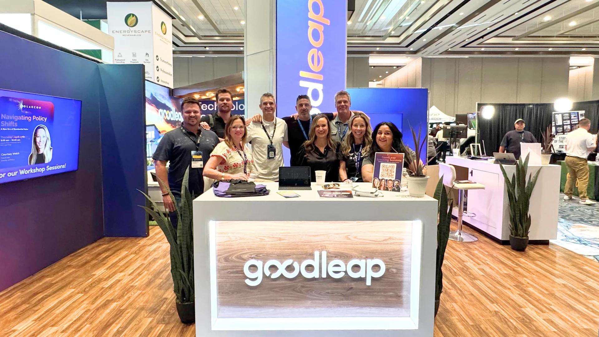 People at a convention standing around a desk with the GoodLeap logo on the front