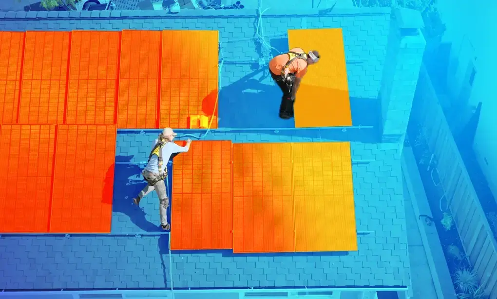 Solar installers installing solar panels on a roof