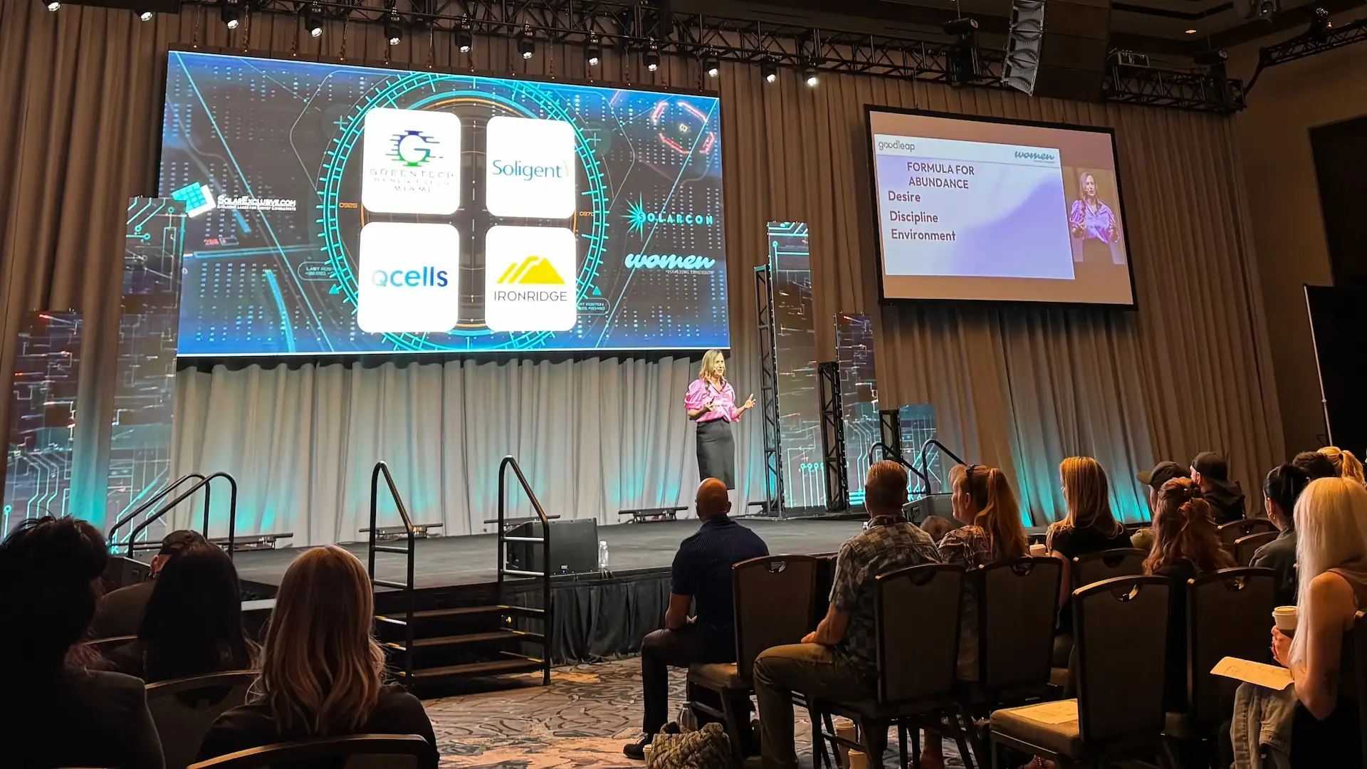 Kelly R presenting on stage at SolarCon 2025