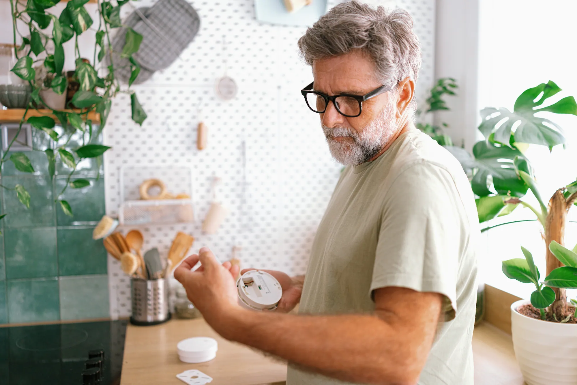 Man installing a smart thermostat in his home