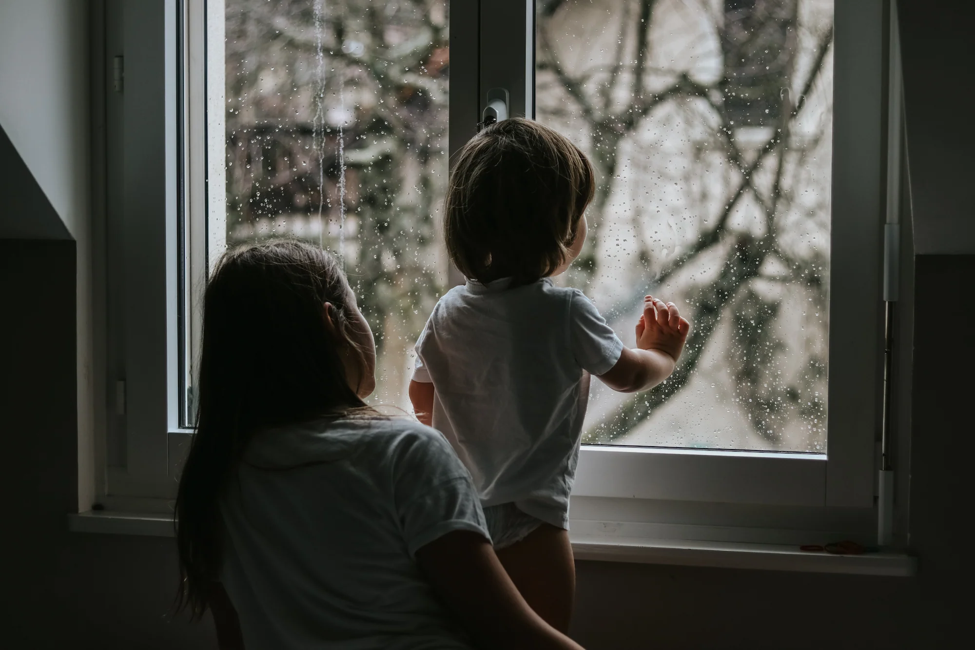 Family looking out window during storm that caused power outage